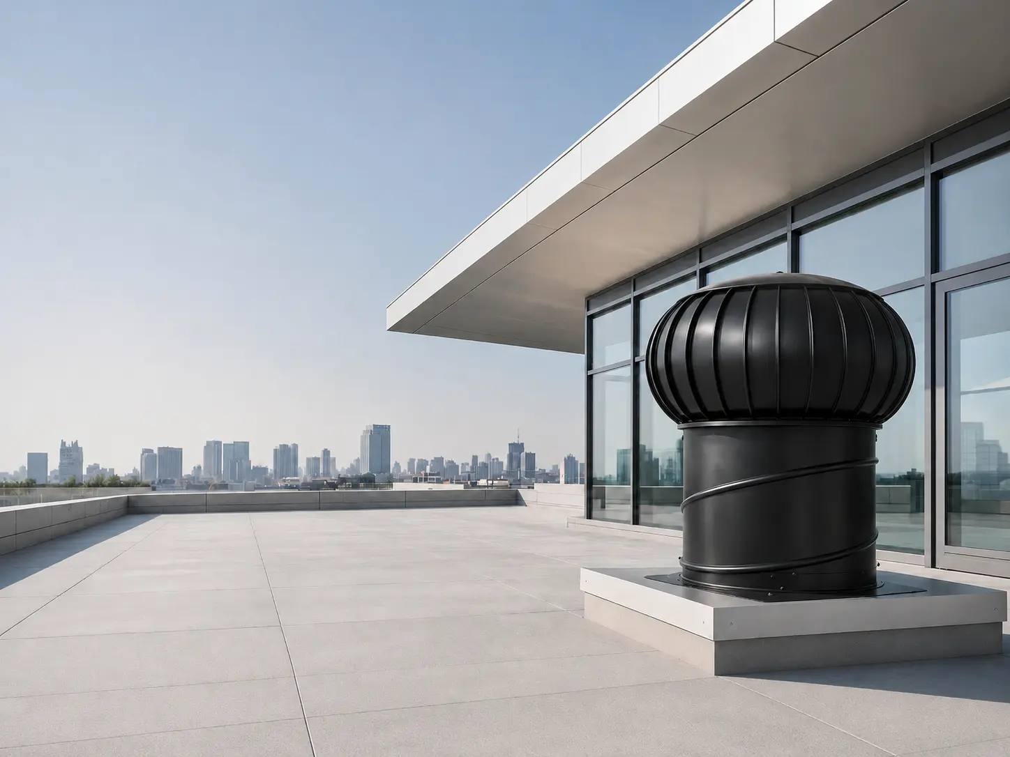 Large silver turbine ventilator on a modern rooftop terrace with a city skyline in the distance.